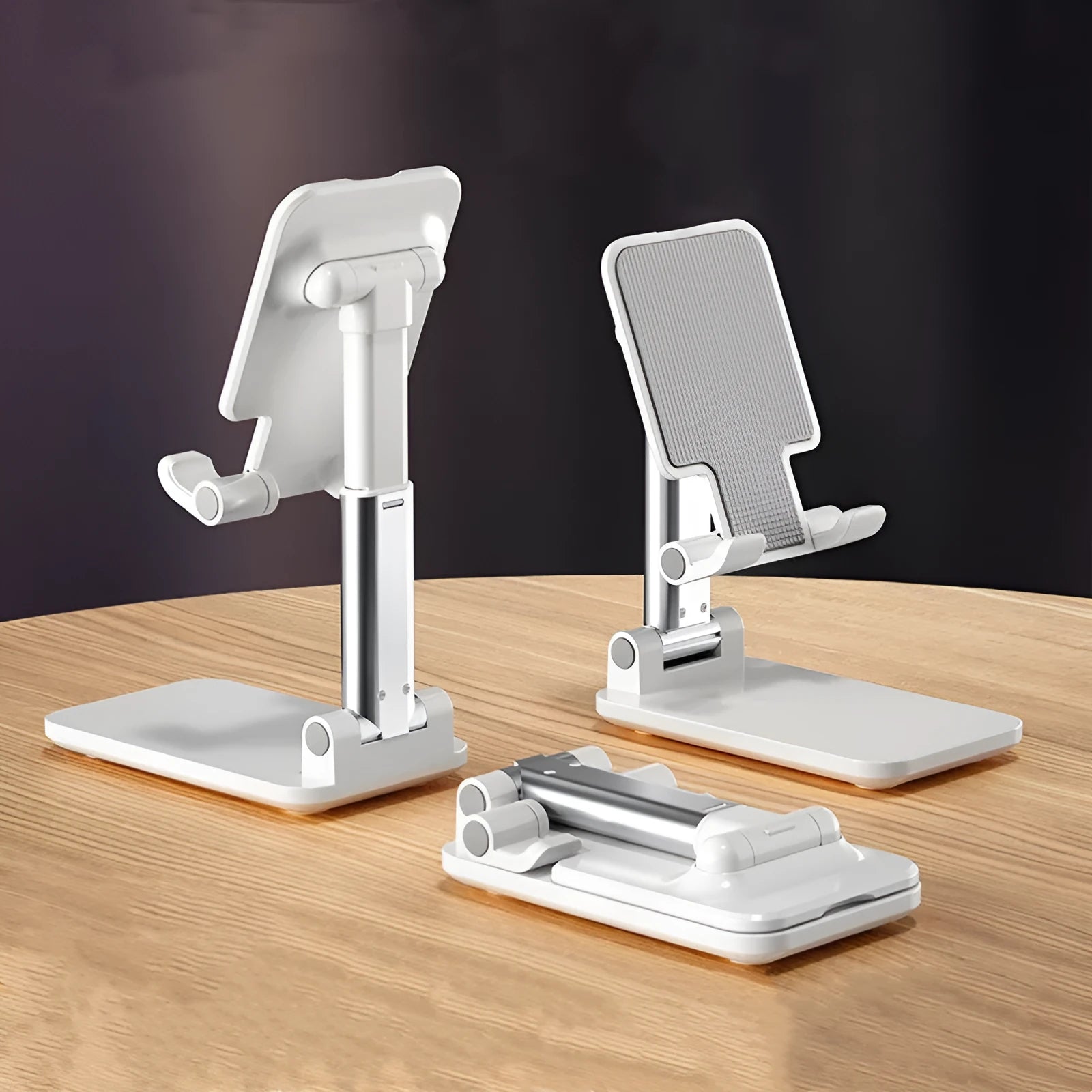 White folding telescopic mobile phone bracket holding a smartphone on a desktop