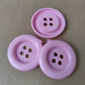 Assortment of oversized round plastic buttons in multiple colours with four holes.