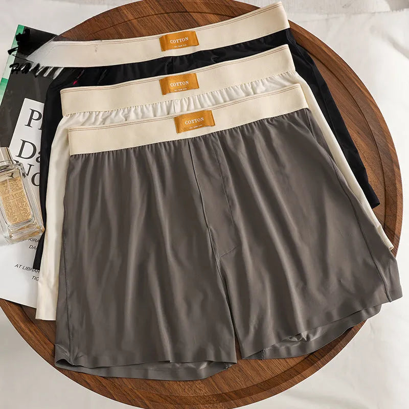 Men's solid colour loose fit ice silk boxer shorts on a mid waist, shown in dark grey.