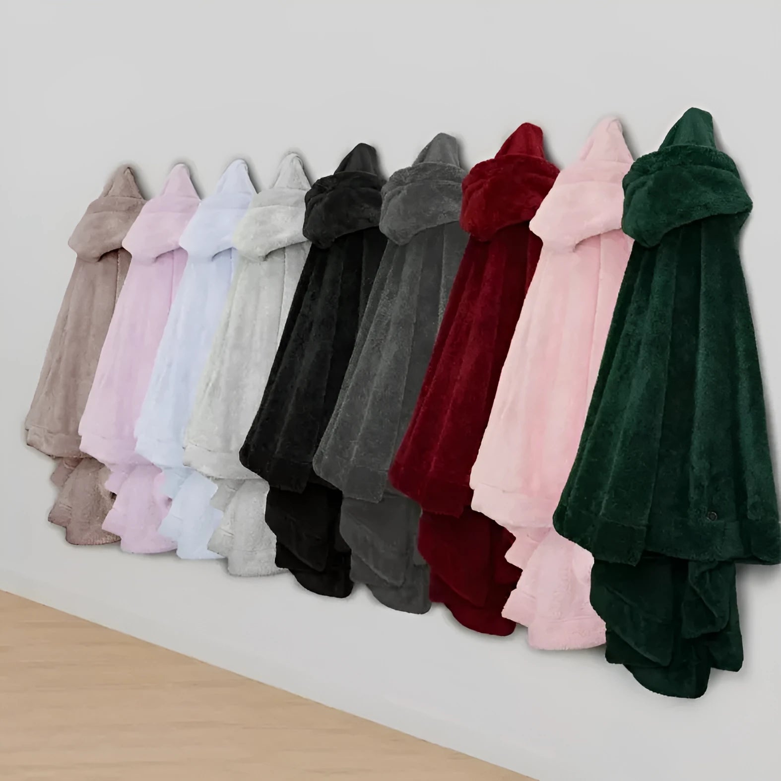Thick pink hooded bathrobe with long sleeves and cardigan front on a hanger.