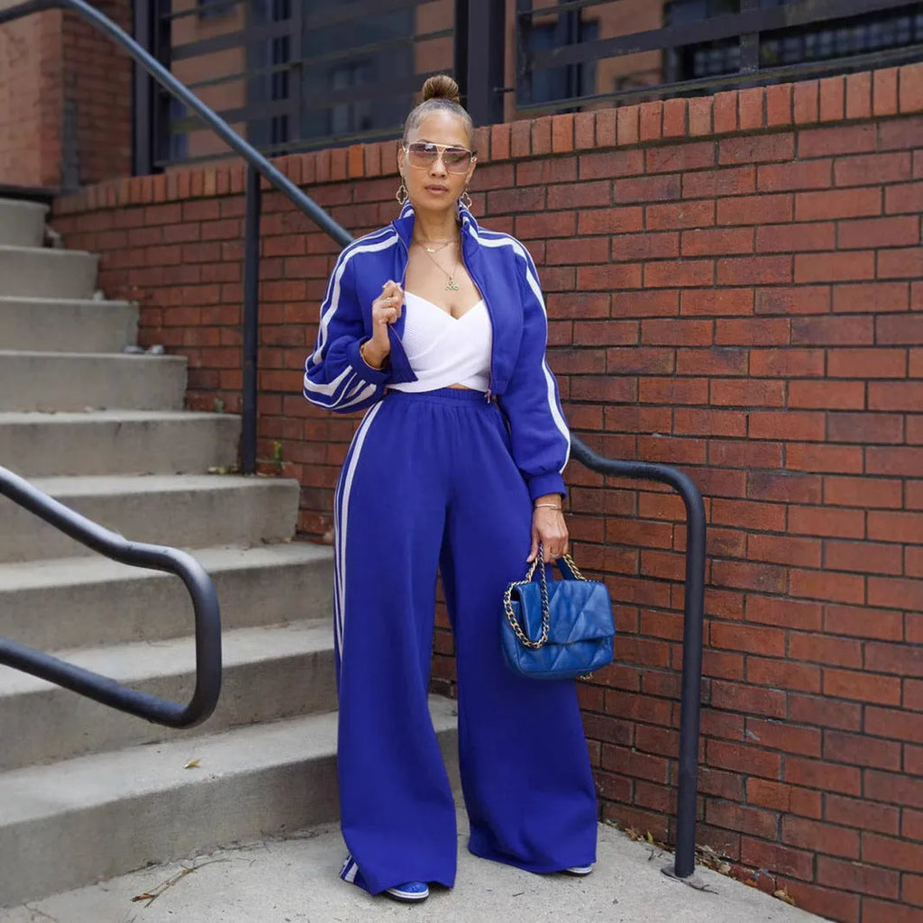 Woman wearing a grey striped zipper sweater and matching trousers from a casual two-piece set.