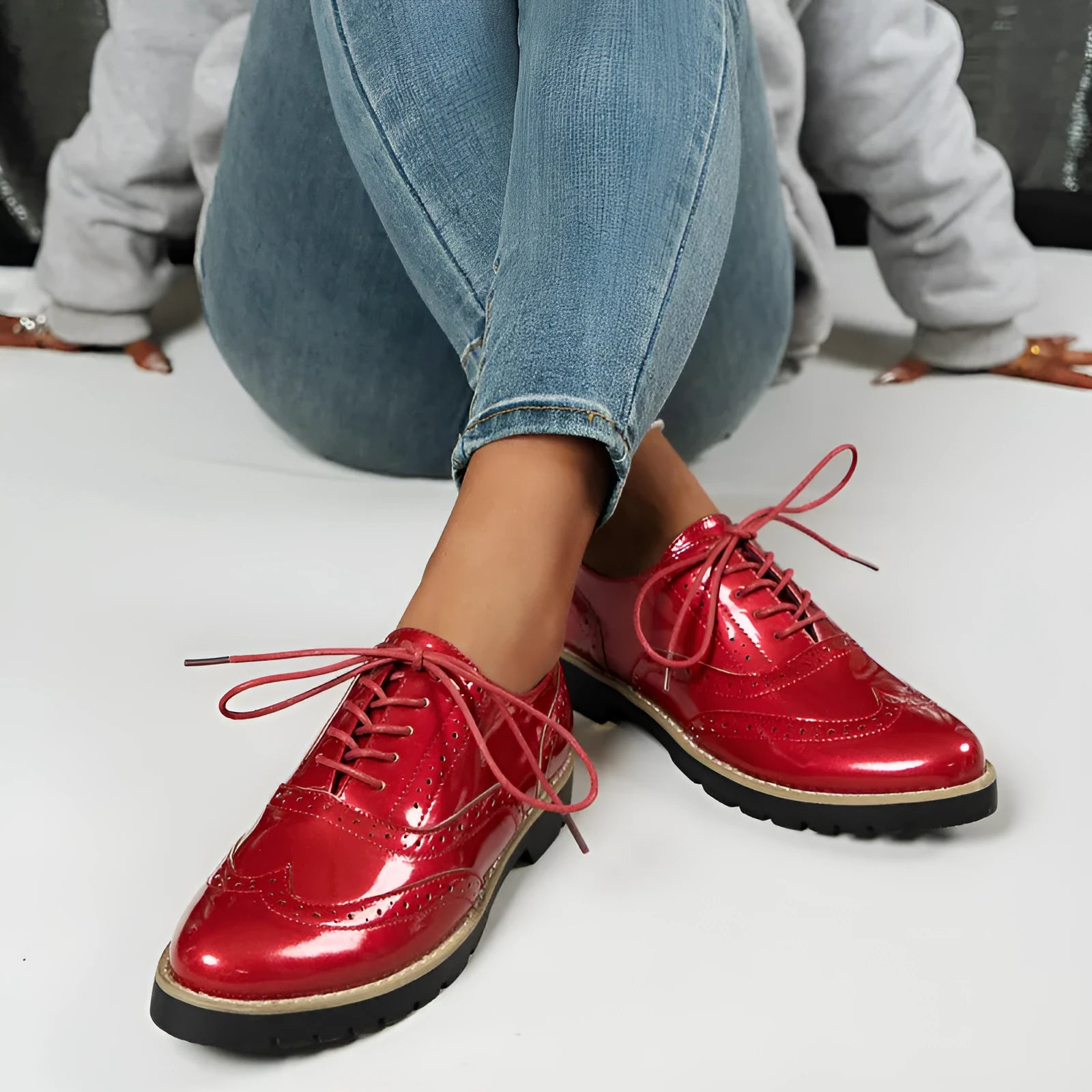 Women's black sequined lace-up loafers with a wedge heel and round toe, shown on a mid-calf.