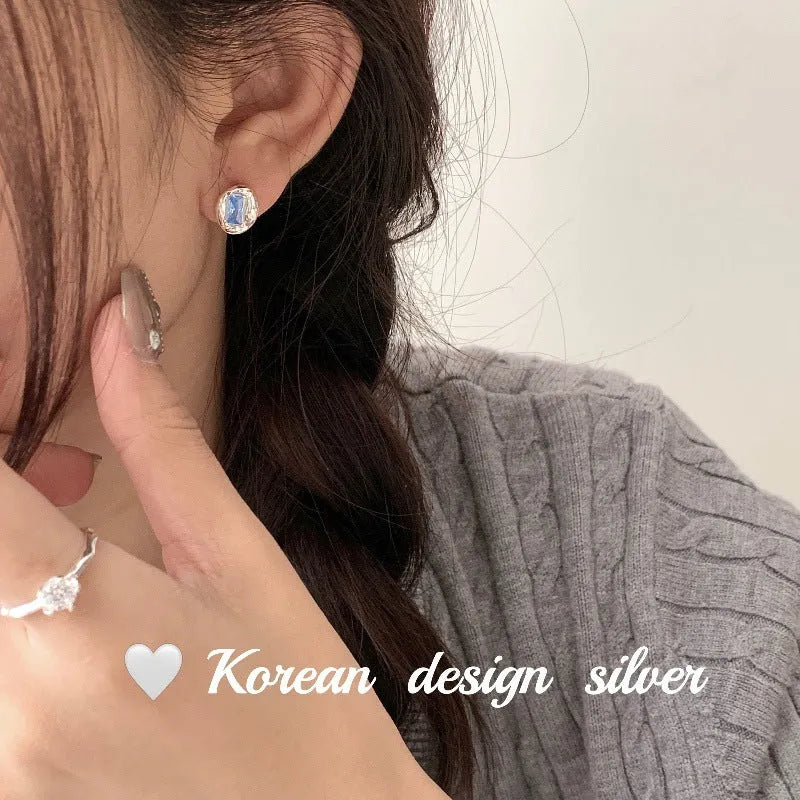 S925 sterling silver oval earrings with heart-wrapped blue diamond design in silver colour
