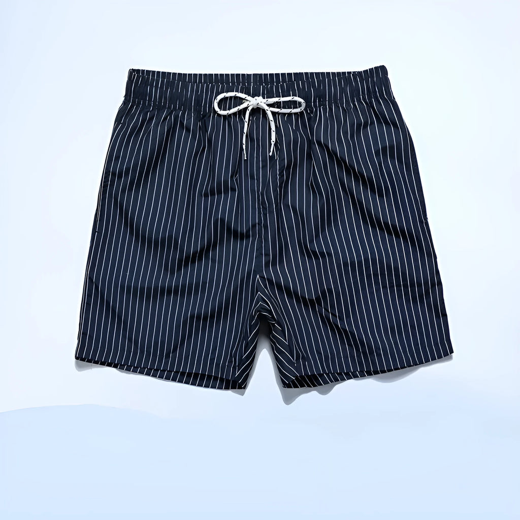 A pair of striped beach shorts in a light blue colour with a straight leg opening, laid flat.