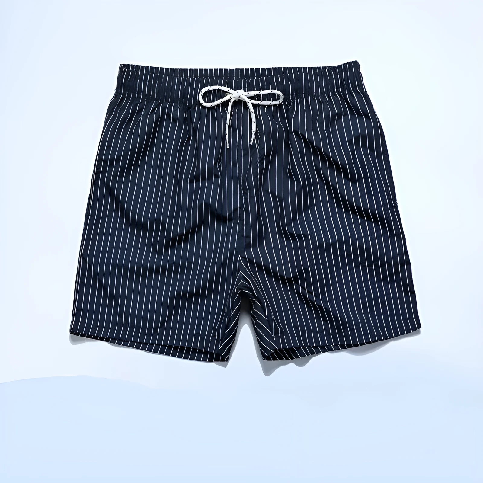A pair of striped beach shorts in a light blue colour with a straight leg opening, laid flat.