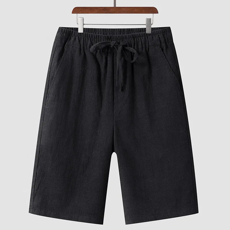 Man wearing beige loose-fit linen cropped shorts with an elastic mid waist.