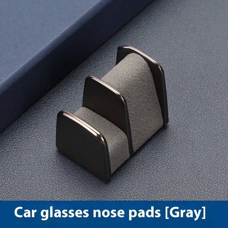 Zinc alloy and leather car dashboard clip for holding sunglasses, shown in green.