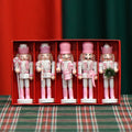Five pink wooden nutcracker soldier puppets each 13cm tall arranged as Christmas garland ornaments