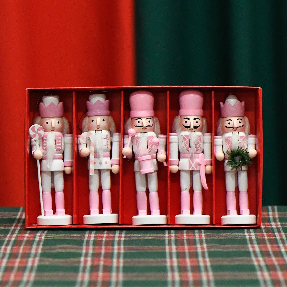 Five pink wooden nutcracker soldier puppets each 13cm tall arranged as Christmas garland ornaments