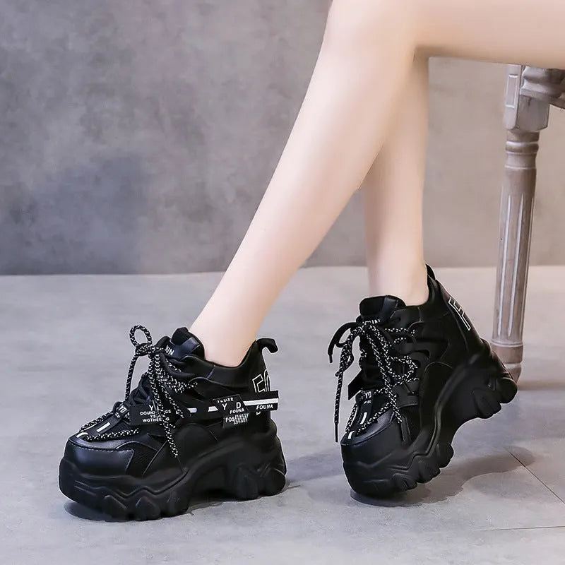 Women's white and black mesh platform sports shoes with cross strap and rubber sole.