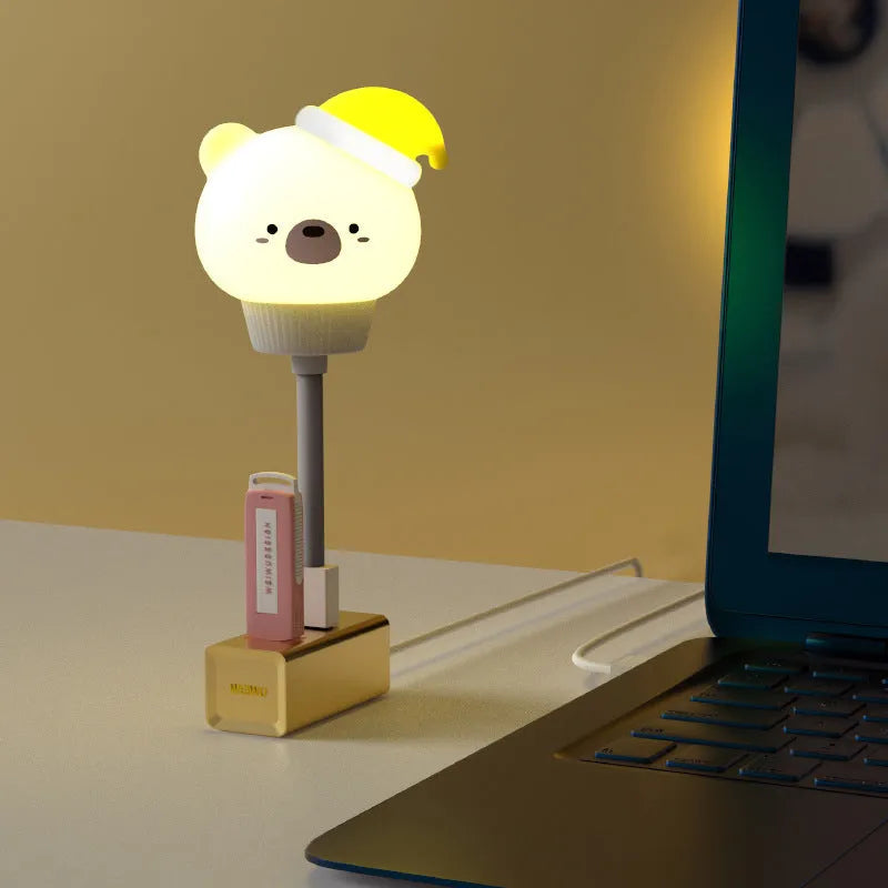 Cartoon animal USB portable LED night light with remote control on a bedside table.