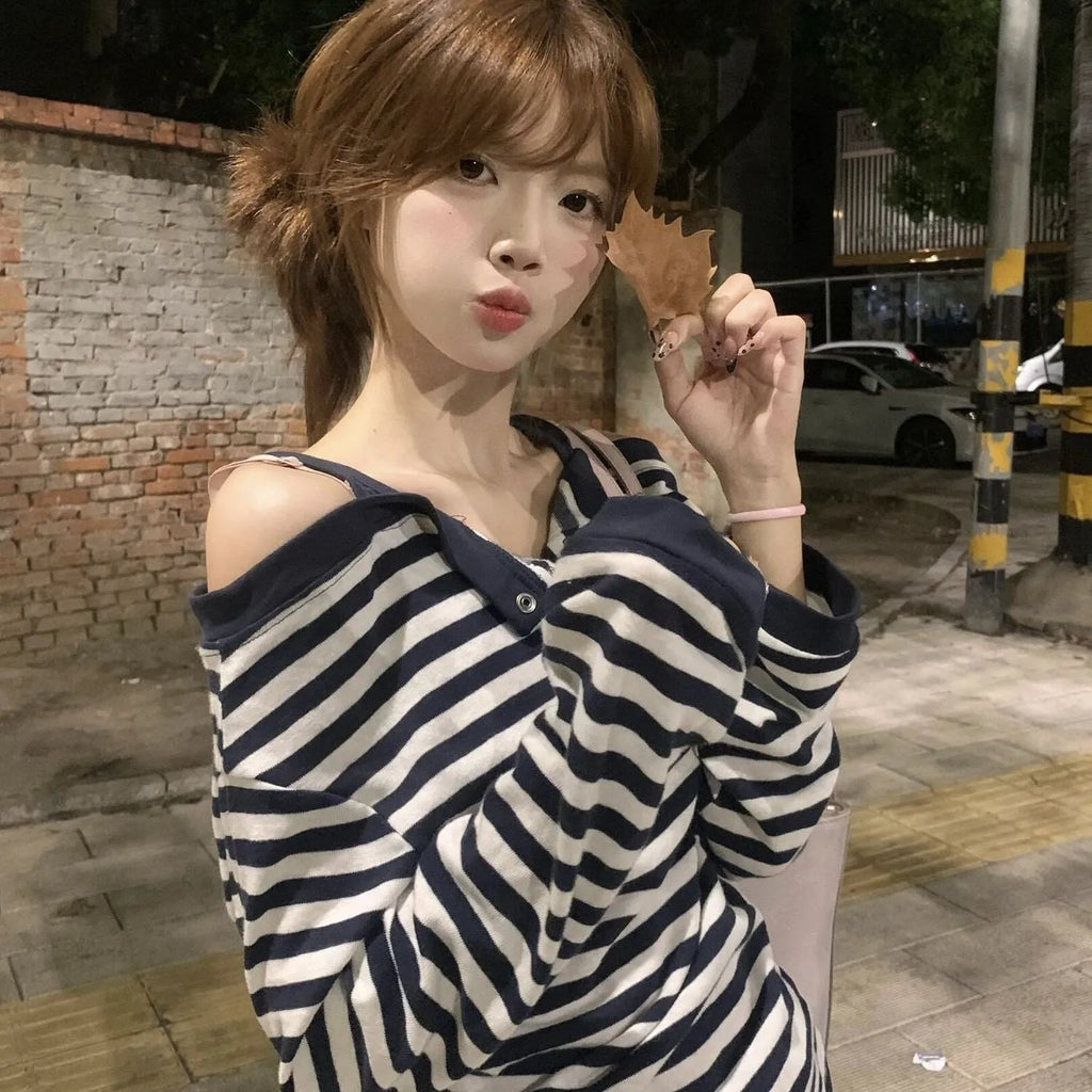Dark blue women's oversized long-sleeved T-shirt with embroidery and stripe details on a hanger.