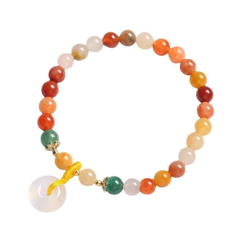 Handmade natural jade and red agate bracelet with silver safety buckle on wooden background