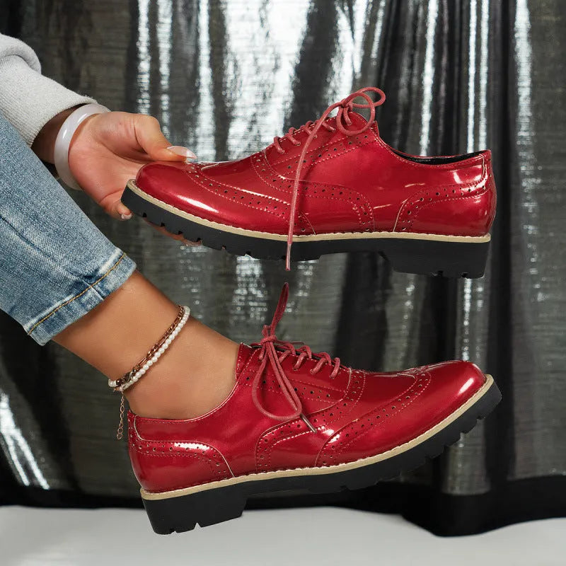 Women's black sequined lace-up loafers with a wedge heel and round toe, shown on a mid-calf.