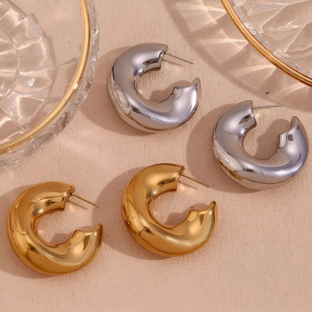 Gold and silver hollow irregular stainless steel earrings with geometric line design on white background