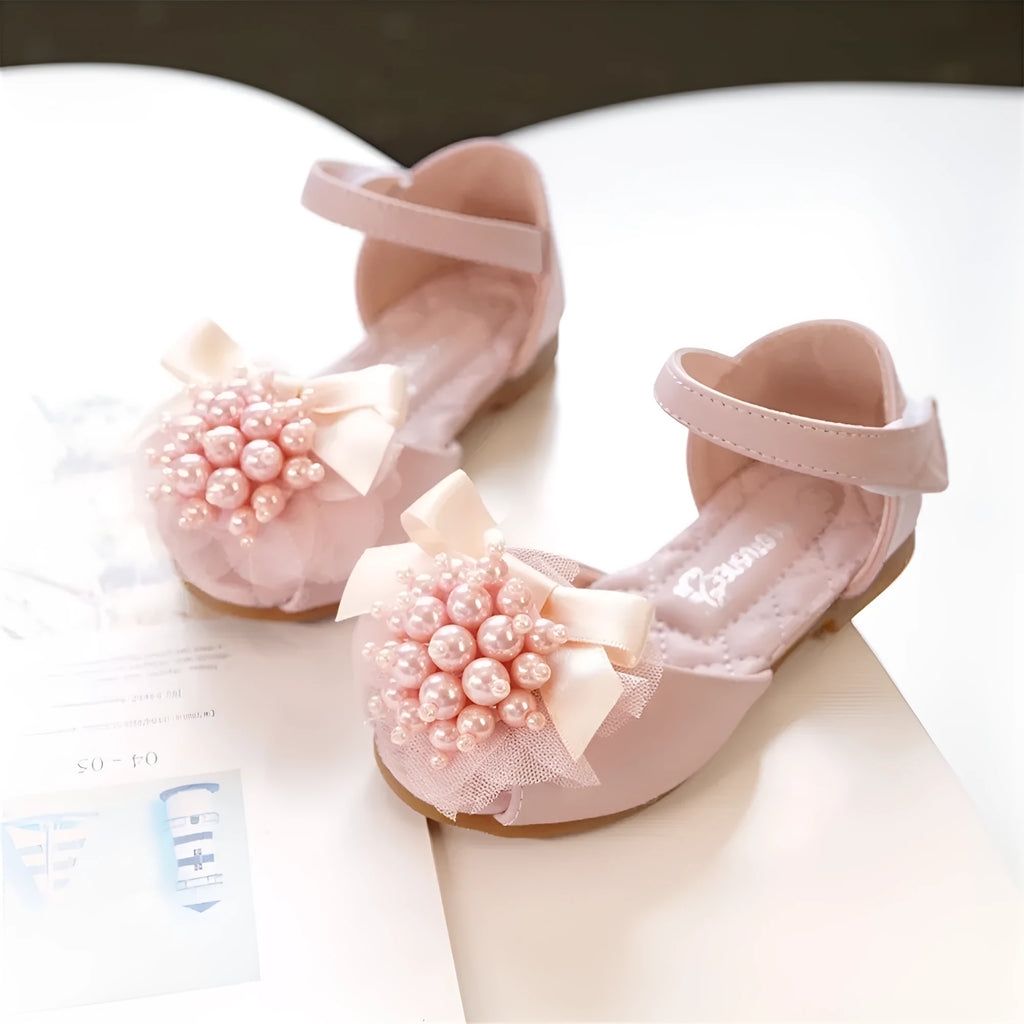 Girls princess-style sandals in beige with peep toe, pearl flower detail, and Velcro strap on a white background