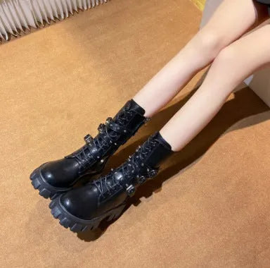 Black mid-calf women's boots with a large metal buckle and side zip on a white background.