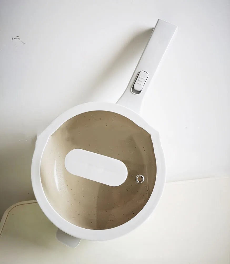 White electric cooking pot with 20cm mouth, 7cm depth, 700W mechanical control, on a dormitory desk