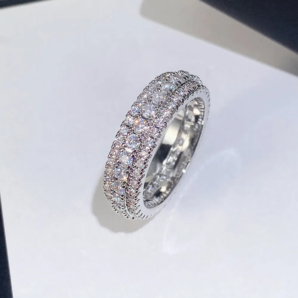 Geometric copper ring with triangular zircon inlay, shown in platinum, yellow gold and white-black finishes.