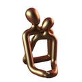 Modern minimalist resin statue of a loving couple in gold or milky white finish.
