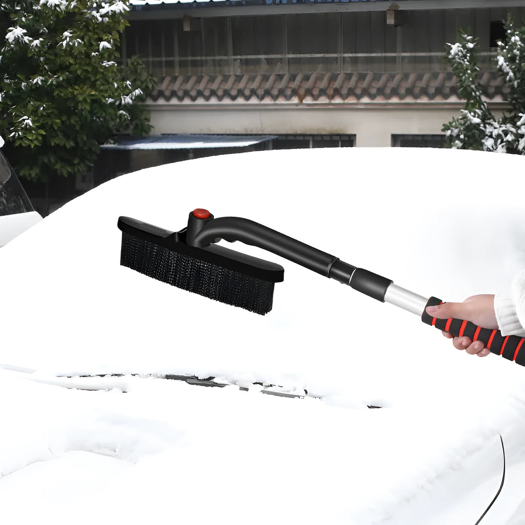 Car deicing shovel with black ABS plastic shovel head and brush, telescopic handle extended, on a windscreen with frost