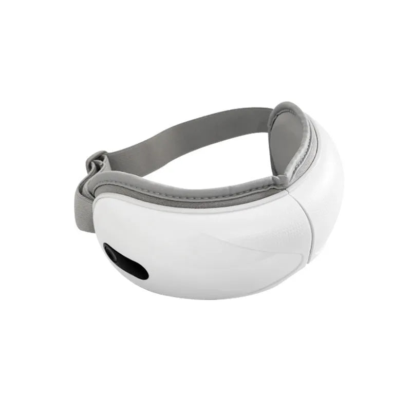 White rechargeable eye massager with airbag massage and hot compress functions on a table