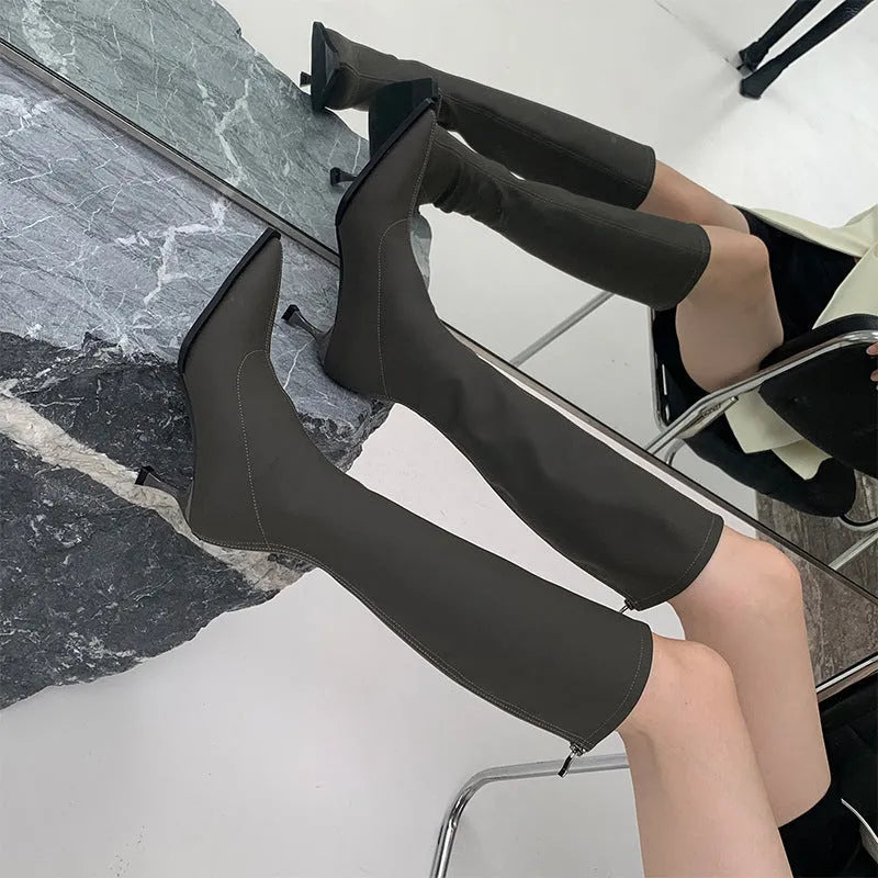 Black women's below-the-knee boots with pointed toe, stiletto heel, and a back zipper.