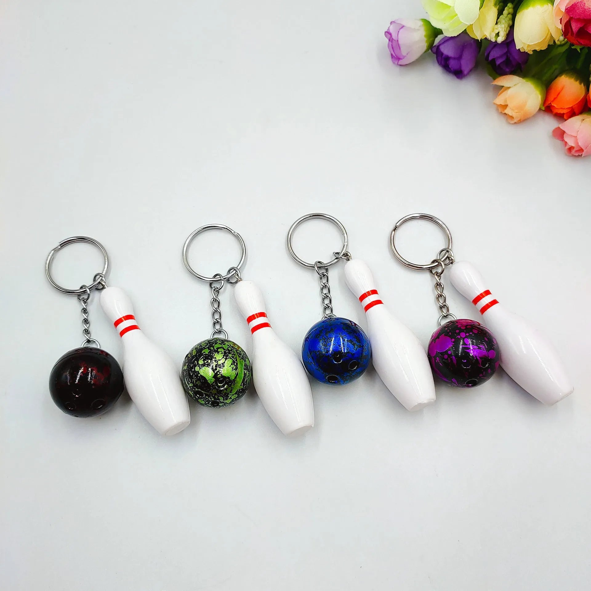 Mini bowling sports keychain pendant in four colour options: dark red, blue, purple, green