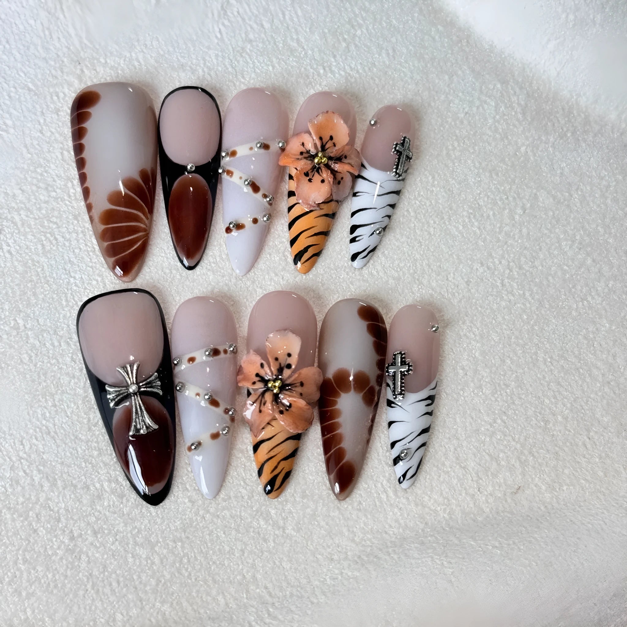 Handmade leopard print false eyelashes with cross and flower details on nail stickers.