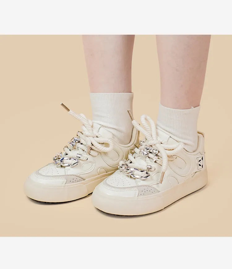 Casual women's white low-top sneakers with rubber sole and lace-up closure on a neutral background