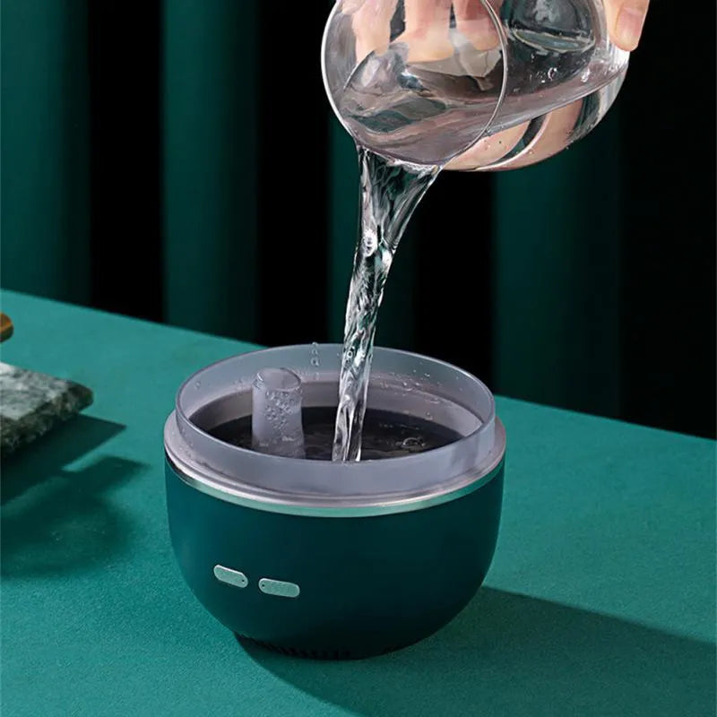 Green ultrasonic humidifier with colourful gradient light on desk showing heavy mist output
