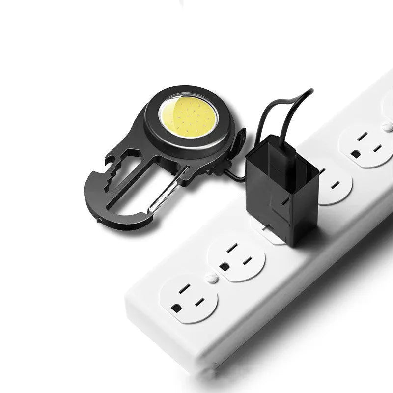 Black 6-in-1 multi-functional mini keychain lamp with COB light and magnetic base on metal surface