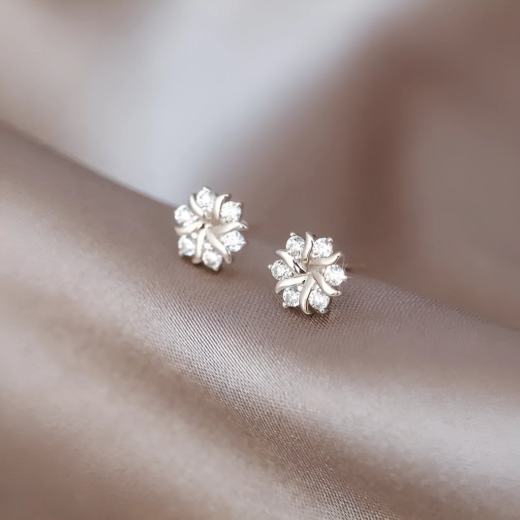 Silver snowflake ear stud earrings for women with zircon detail and copper base, geometric compact design.