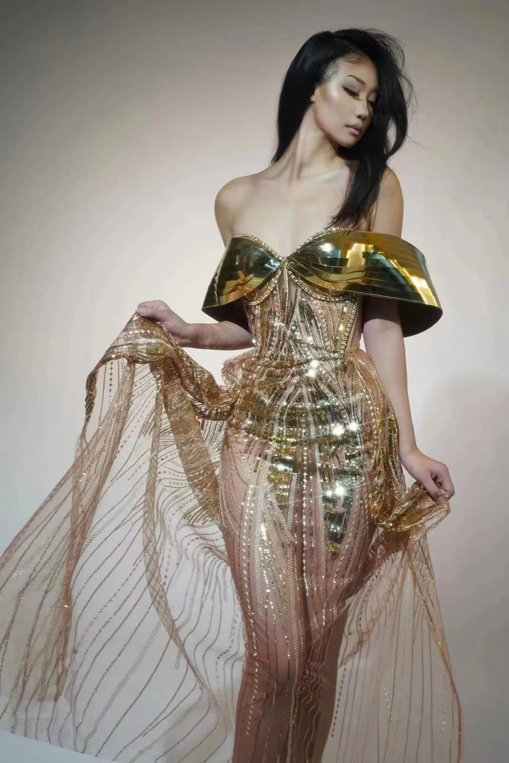 Gold strapless sequin dress with sleeveless tube top and long one-step skirt.
