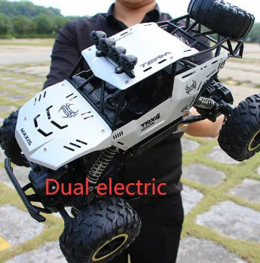 Large black 4WD remote control off-road climbing car on a rocky surface.