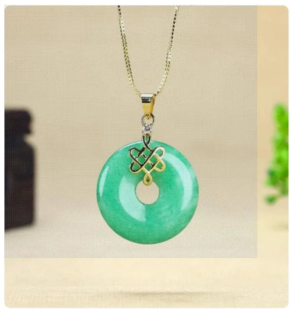 Dry green jade coin buckle pendant 25mm diameter on a light background