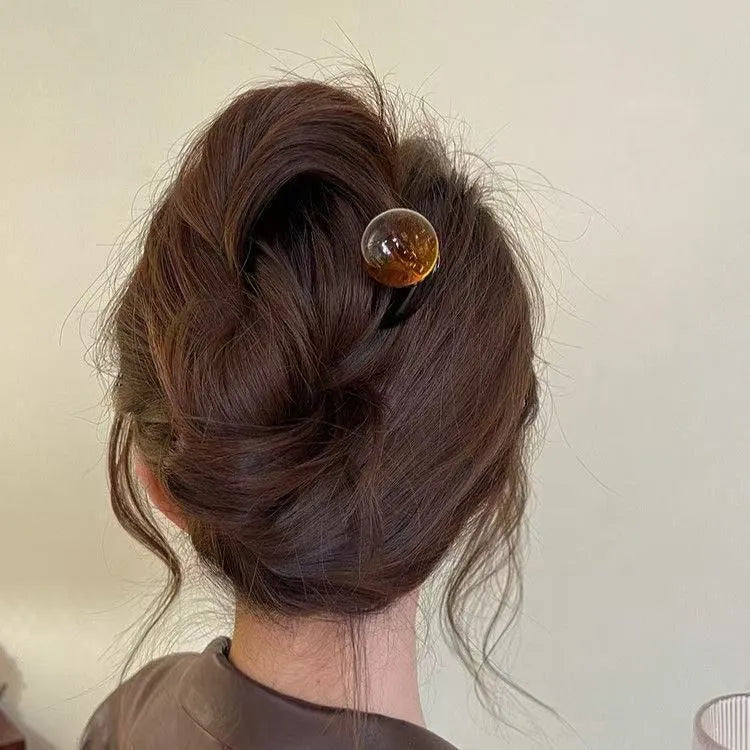 Acrylic U-shaped hair barrette with a small spherical decoration in a beige and caramel two-tone colour combination.