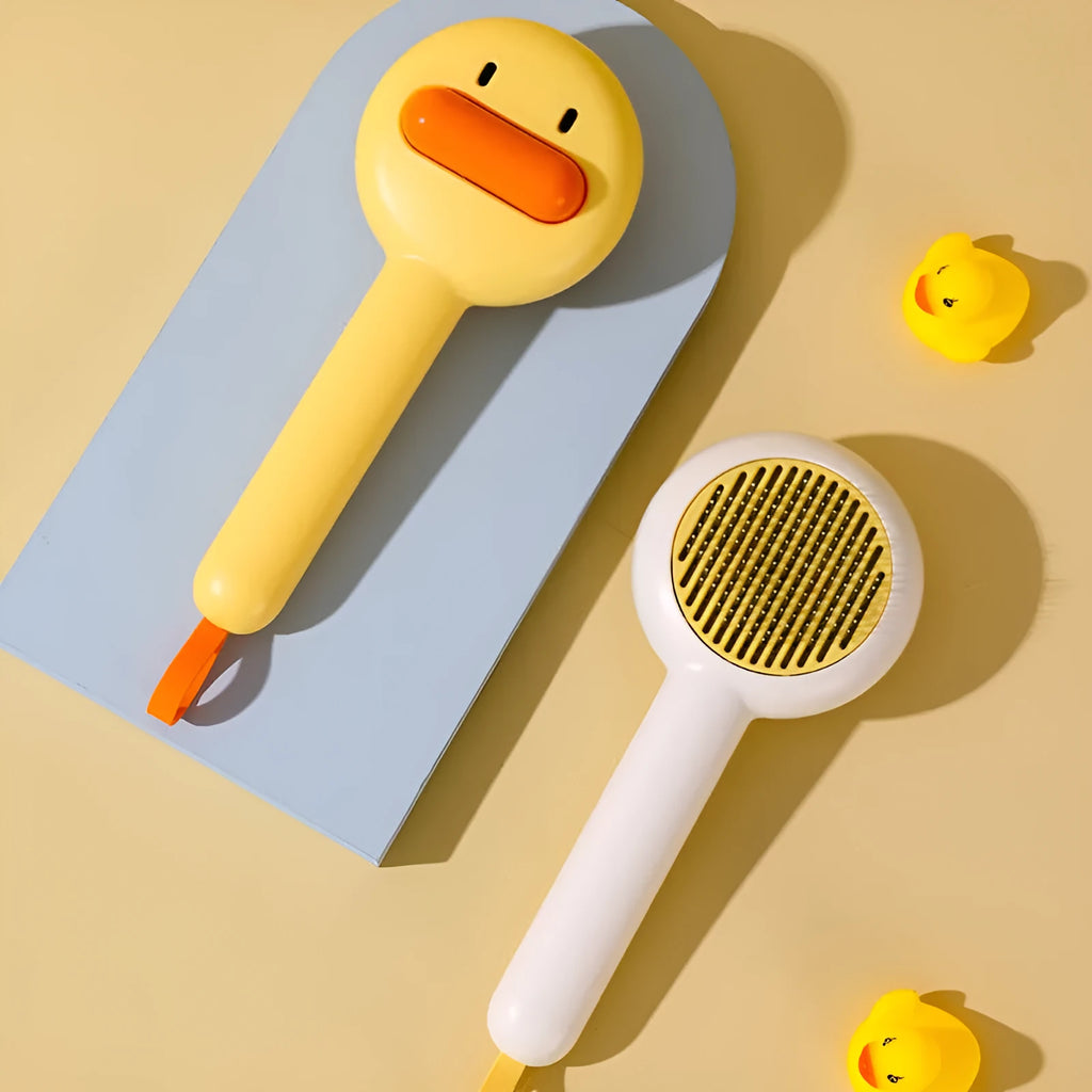 Small yellow duck-shaped pet grooming comb with open needle brush for cats and dogs