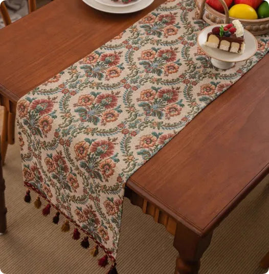 Long blue ginkgo leaf patterned table flag with tassels draped over a wooden sideboard.