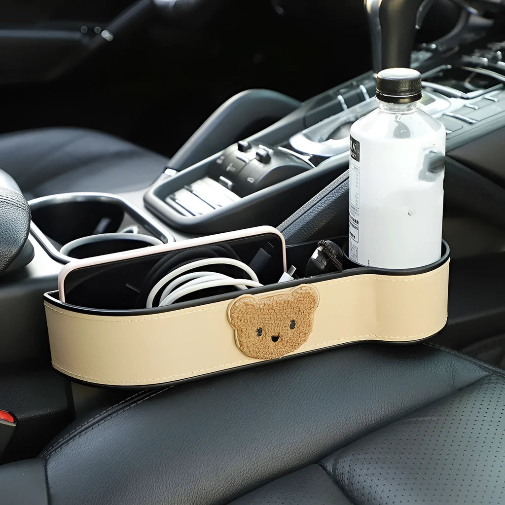Leather car seat gap storage box with cartoon bear design, shown fitted next to a car seat.