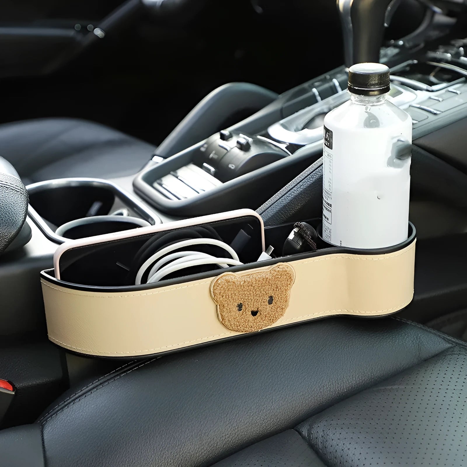 Leather car seat gap storage box with cartoon bear design, shown fitted next to a car seat.