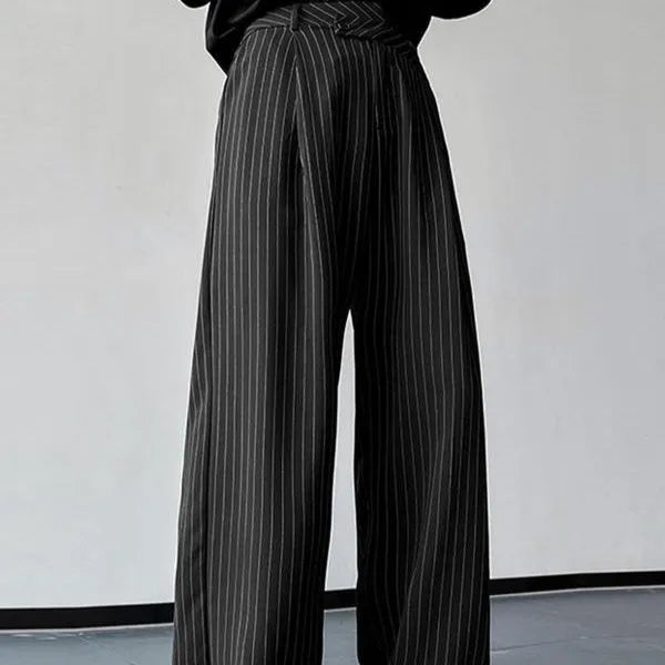 Man wearing black vertical striped pleated casual trousers with an elasticated waistband.