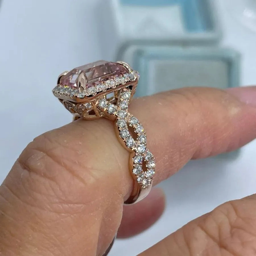 Geometric rose gold alloy ring on a plain background, showing its angular shape and metallic finish.