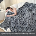 Double-layer jacquard taffeta blanket with leopard print pattern in a camel colour, laid flat on a bed.
