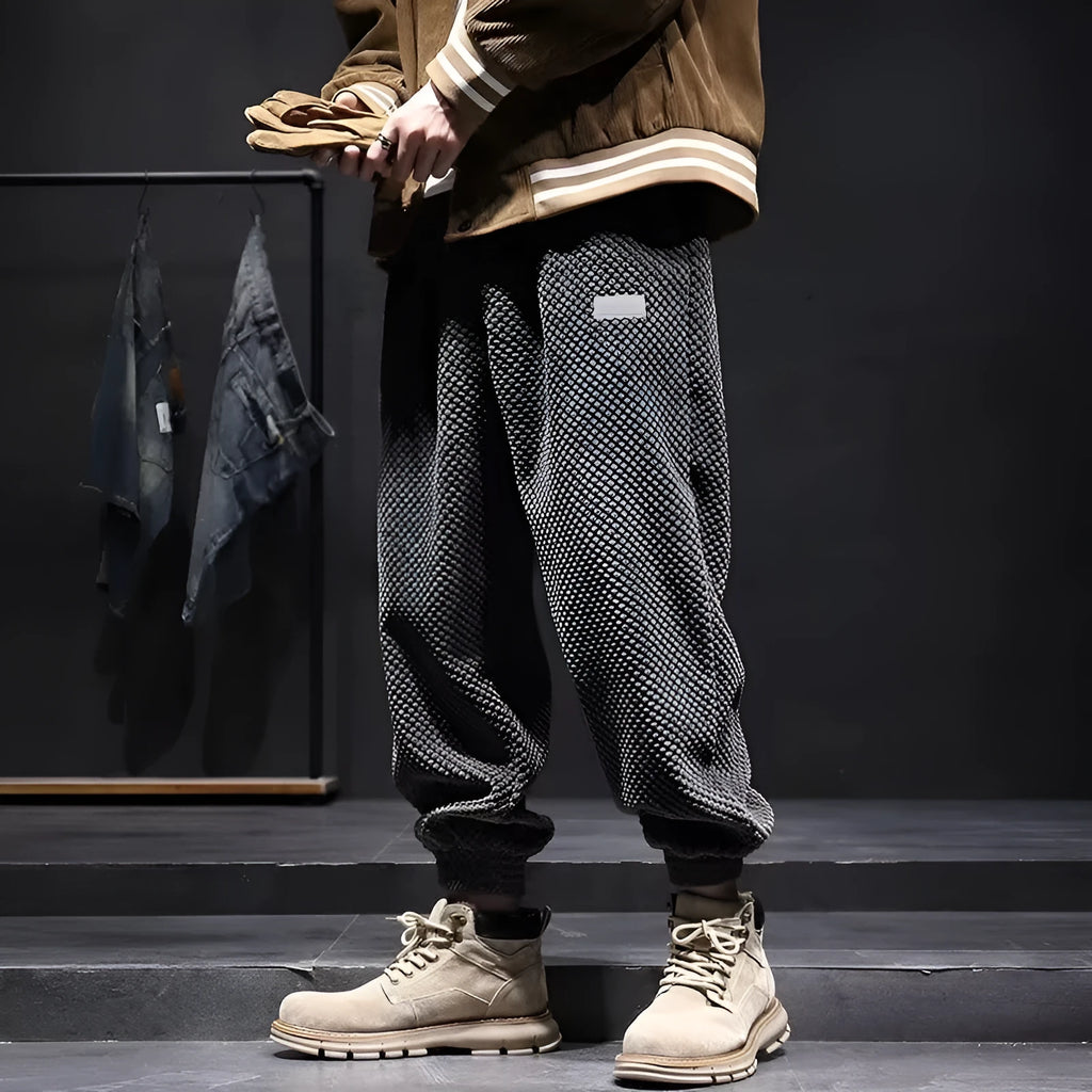 Men's grey ankle-tie sweatpants with a straight leg on a plain background