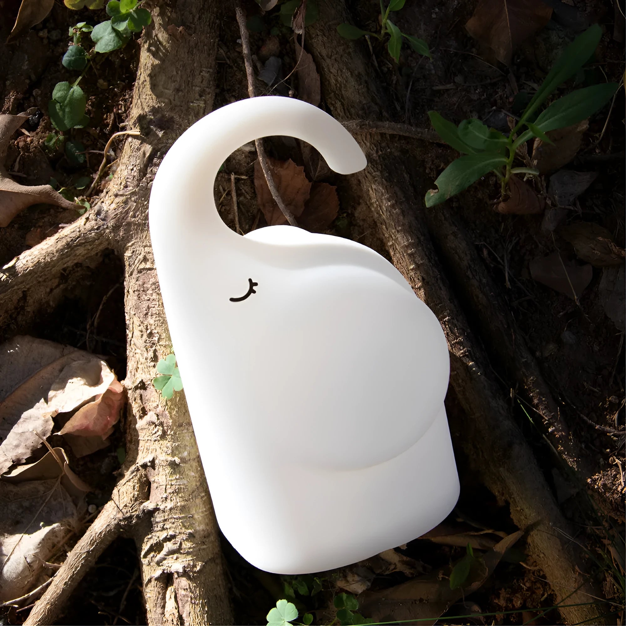 DOMI Elephant-shaped silicone USB night light with warm white glow on a bedside table.