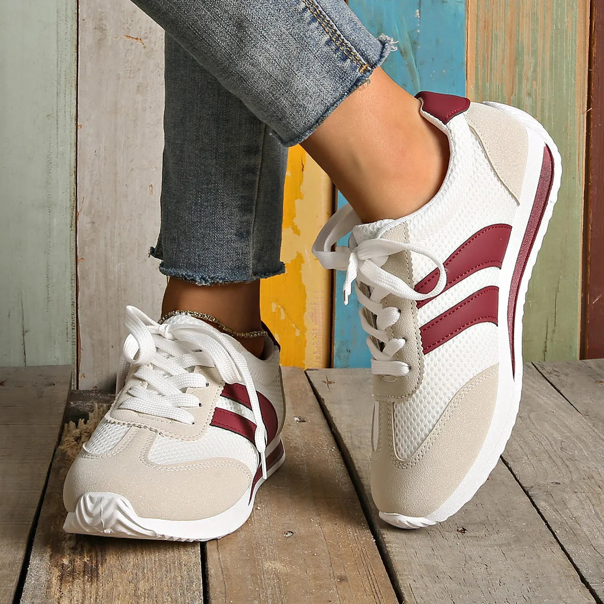 Wine red Cortez Retro sneaker with mesh upper, cross strap, and flat rubber sole.