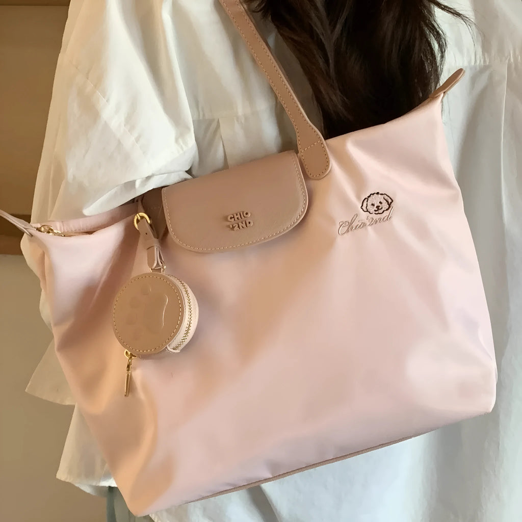 Large pink Oxford cloth tote shoulder bag showing external sandwich pocket and casual design.