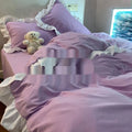 Mori style solid colour linen four-piece bedding set with quilt cover, sheet, and pillowcases on a bed.