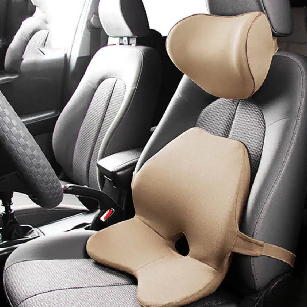 Black memory foam car lumbar support cushion with elastic straps, shown on a grey car seat.